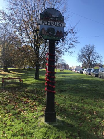 Village sign decorated with poppies